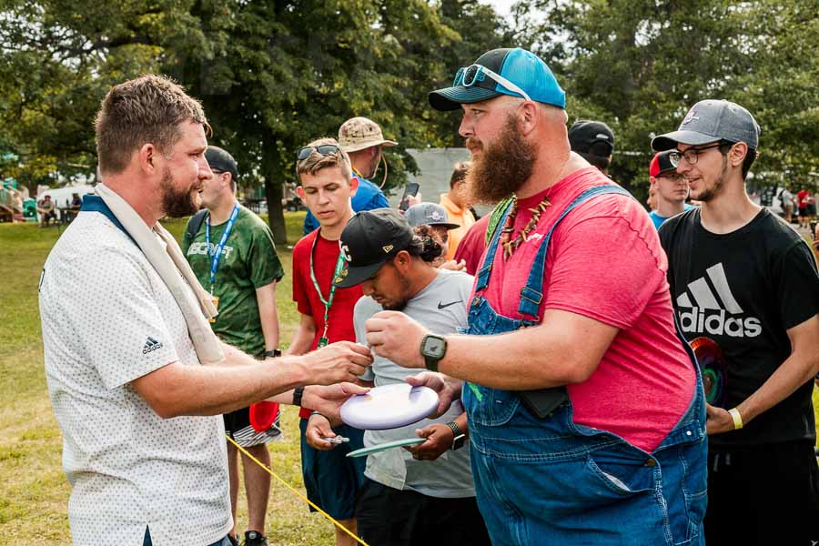 Professional disc golfer Nate Sexton signing an autograph